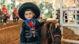 Wish kid Angelito standing next to a horse